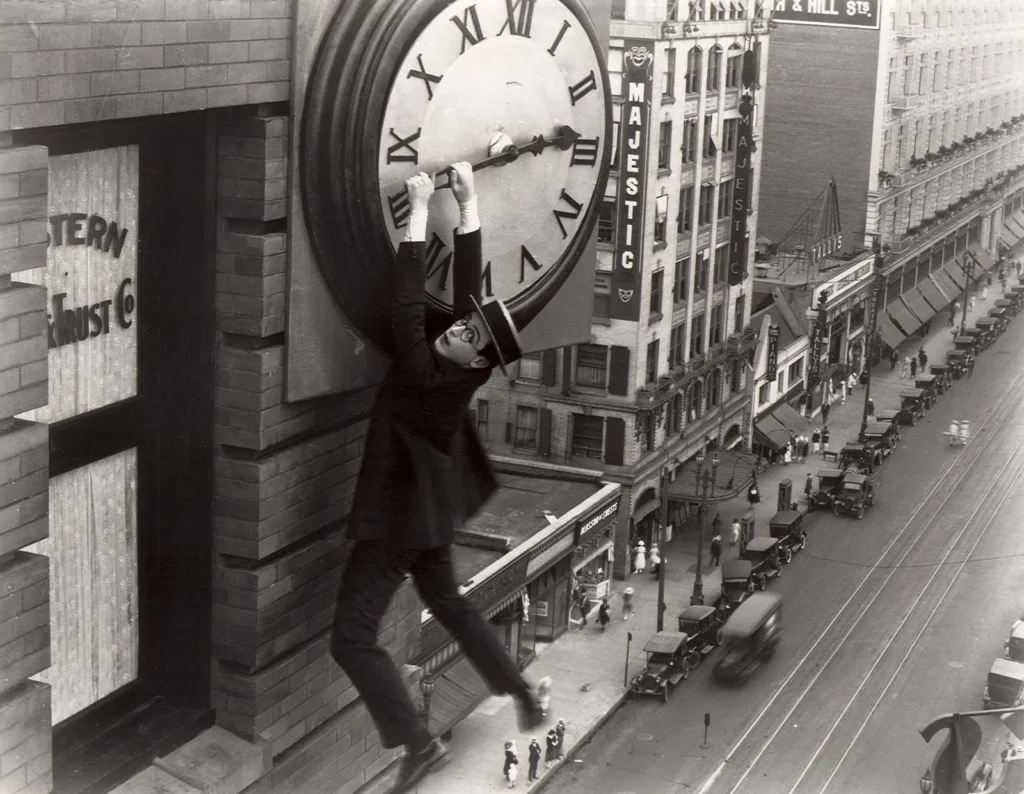 Harold Lloyd, em cena de Safety Last! (1923) ou "O Homem Mosca", como foi chamado aqui no Brasil. O filme é provavelmente sua obra mais conhecida e conta com cenas de tirar o fôlego (como essa da imagem), a maioria delas feitas por Lloyd sem auxílio de dublê. Créditos: Pathé Exchange.